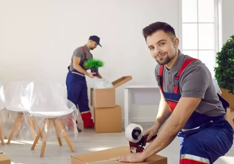 Funcionários de empresa embalando mudança.