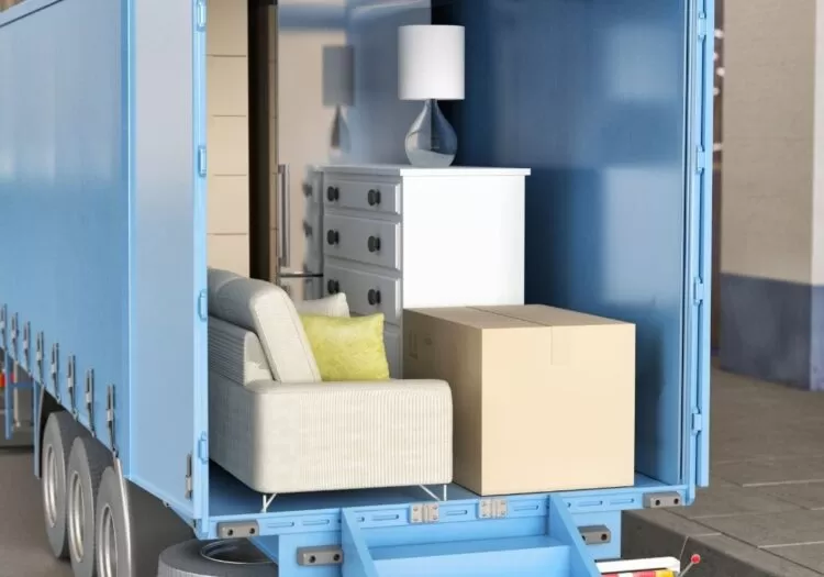 Caminhão com traseira aberta e móveis dentro.