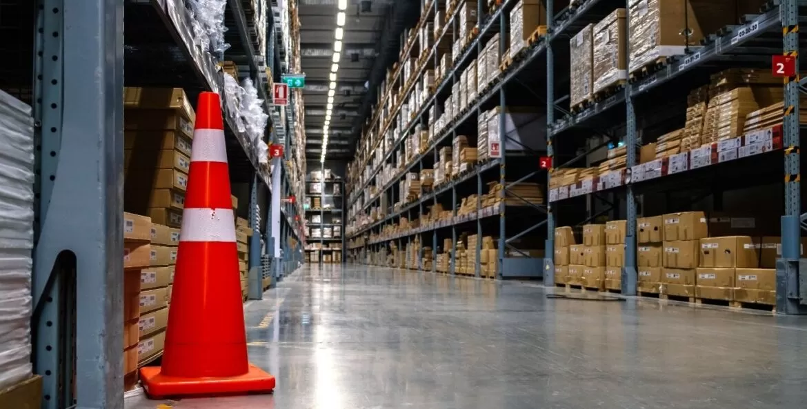 Estocagem: corredor com prateleiras até o teto com caixas e produtor estocados.