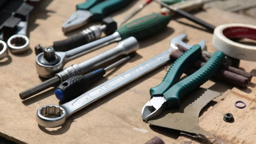 Alicates e chaves de fenda encima de mesa.