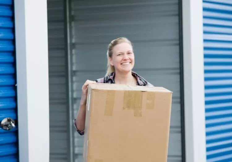 Mulher carregando caixa de papelão.