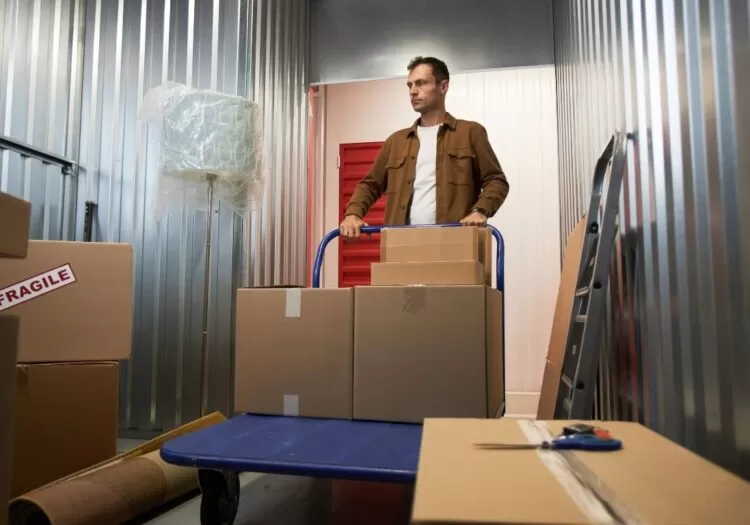 Homem guardando caixas em unidade de armazenagem.