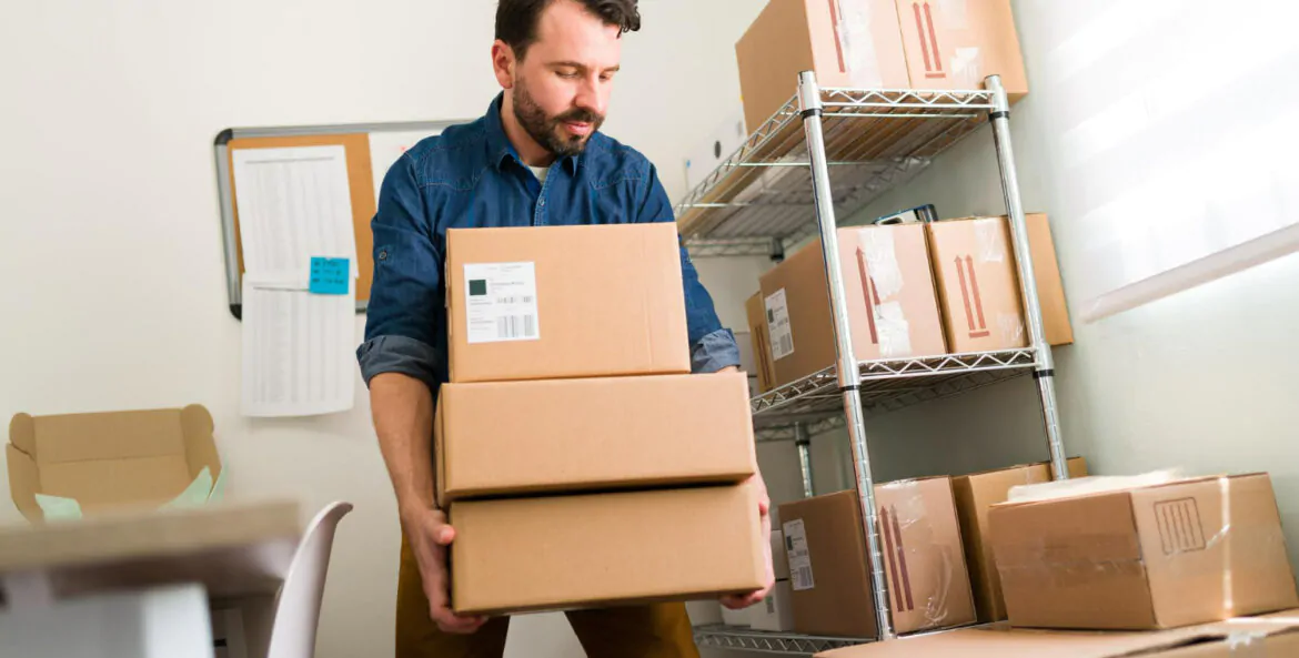 Como organizar um estoque: Homem carregando caixas